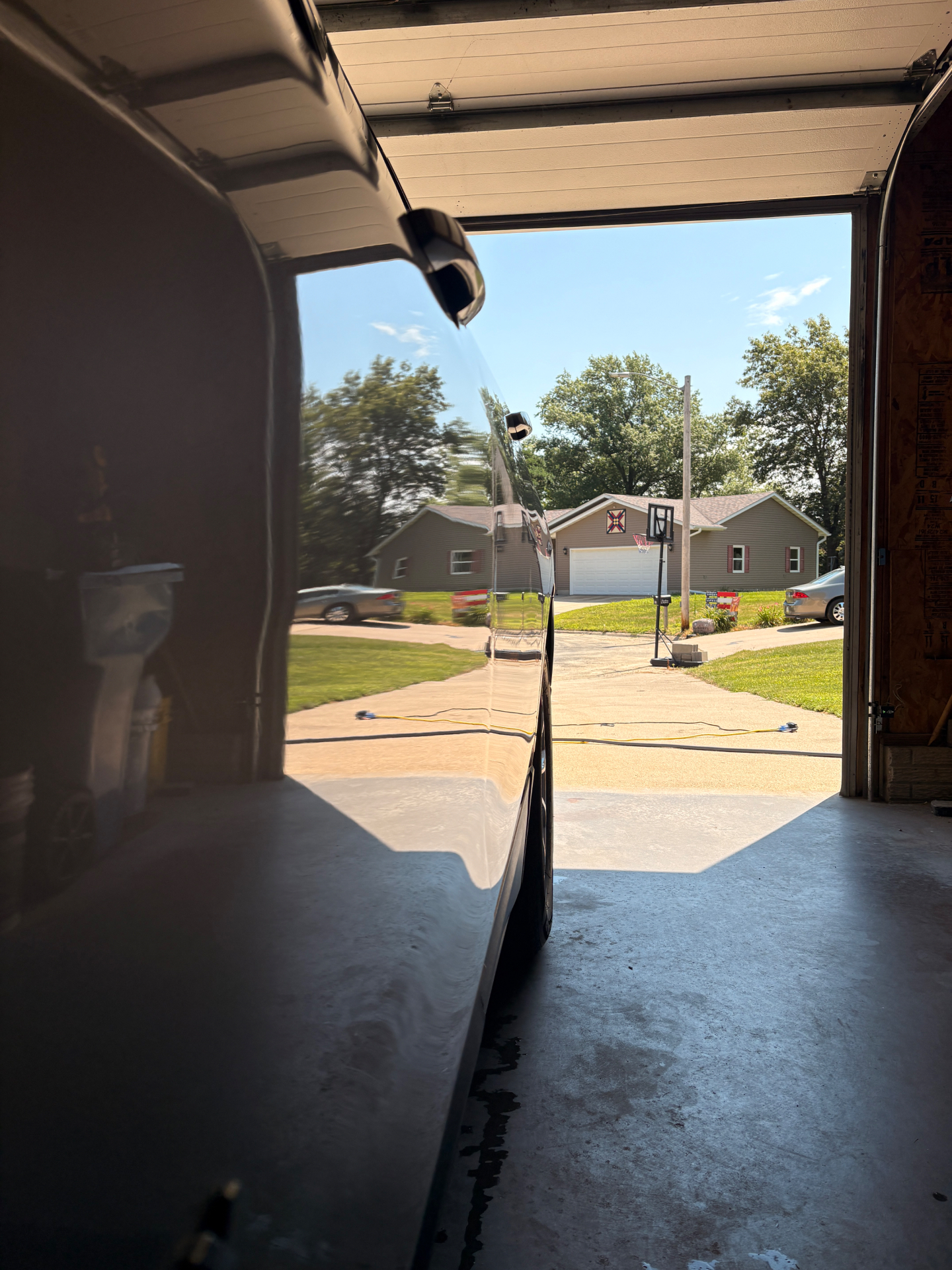 Glossy black vehicle in a detailing garage with a flawless mirror finish
